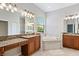 Large bathroom with granite double vanity, soaking tub, and shower at 134 Savona Way, North Venice, FL 34275