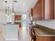 Kitchen boasts granite counters, wood cabinets and breakfast bar at 134 Savona Way, North Venice, FL 34275