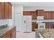 Modern kitchen featuring granite countertops and wood cabinets at 134 Savona Way, North Venice, FL 34275