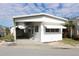 White single-wide mobile home with carport and small yard at 149 S Port Dr, Venice, FL 34285