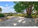 Large backyard patio shaded by a mature tree, surrounded by landscaping at 1745 S Gondola Ct, Venice, FL 34293