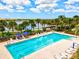 Community lap pool with lounge chairs, umbrellas, and a waterfront view at 19267 Kirella St, Venice, FL 34293