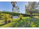 Peaceful backyard with a white swing bench and lush greenery at 19348 Yellowtail Ct, Venice, FL 34292