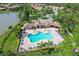 Aerial view of resort-style pool with lounge chairs and community clubhouse at 19348 Yellowtail Ct, Venice, FL 34292