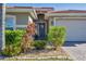 Landscaped front yard with tropical plants and a paved driveway at 19348 Yellowtail Ct, Venice, FL 34292