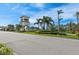 Attractive community entrance with a stately tower and lush landscaping at 19397 Rizzuto St, Venice, FL 34293