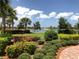 Landscaped area with flowering bushes and a lake view at 19764 Ortona St, Venice, FL 34293