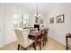 Charming dining area featuring a wood table, upholstered chairs, and plantation shutters at 20460 Granlago Dr, Venice, FL 34293