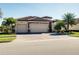 Home with a three-car garage, tile roof, and front landscaping at 20460 Granlago Dr, Venice, FL 34293