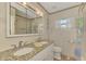 Bathroom with double vanity, granite countertop and large mirror at 225 Firenze W Ave, Venice, FL 34285
