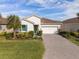 Single-story home with a two-car garage and landscaping at 228 Daylily Blvd, Nokomis, FL 34275