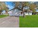 House exterior showcasing a large tree and grassy lawn at 2281 Mars Rd, Venice, FL 34293