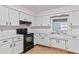 White kitchen cabinets, black appliances, and a window at 2281 Mars Rd, Venice, FL 34293