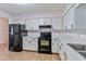 Kitchen features white cabinets, black appliances, and tile floor at 2281 Mars Rd, Venice, FL 34293