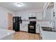 View of kitchen with black appliances and white cabinets at 2281 Mars Rd, Venice, FL 34293