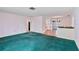 Open living area with teal carpet, a view of the kitchen, and a brick half wall at 2281 Mars Rd, Venice, FL 34293