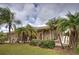 House with palm trees and lush landscaping in the front yard at 23102 Madelyn Ave, Port Charlotte, FL 33954