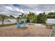 Brick patio with fire pit and blue chairs at 23102 Madelyn Ave, Port Charlotte, FL 33954