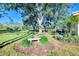 Serene backyard oasis featuring lush landscaping, a stone bench, and a screened-in patio at 2331 Harrier Way, Nokomis, FL 34275