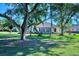 Mature trees and lush lawn surround the home's exterior at 2331 Harrier Way, Nokomis, FL 34275