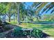 Landscaped backyard with a stone bench and tranquil setting at 2331 Harrier Way, Nokomis, FL 34275