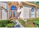Welcoming front entry with arched doorway and lush landscaping at 2331 Harrier Way, Nokomis, FL 34275