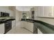 Kitchen boasts white cabinets, granite counters, and stainless steel appliances at 2331 Harrier Way, Nokomis, FL 34275