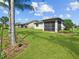An inviting backyard shows the screened lanai, a secure black metal fence, and lush landscaping, perfect for relaxation at 2501 Sherman Oak Dr, North Port, FL 34289