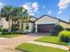 Attractive one-story home showcasing a brick driveway, well-kept lawn, and verdant landscaping at 2501 Sherman Oak Dr, North Port, FL 34289