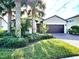 Charming single-story home with a well-manicured lawn and beautiful palm tree landscaping in front at 2501 Sherman Oak Dr, North Port, FL 34289