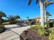 Community outdoor seating area with tables, chairs, umbrellas, and lush landscaping, creating a relaxing gathering space at 2501 Sherman Oak Dr, North Port, FL 34289
