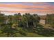 Landscaped backyard with palm trees and seating area at sunset at 2572 Daisy Dr, North Port, FL 34289