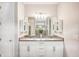 Double vanity bathroom with white cabinets and a large mirror at 2572 Daisy Dr, North Port, FL 34289