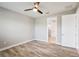 Bedroom with wood-look floors, ceiling fan and access to a bathroom at 2572 Daisy Dr, North Port, FL 34289