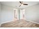 Bright bedroom with wood-look floors, ceiling fan, and access to bathroom and kitchen at 2572 Daisy Dr, North Port, FL 34289