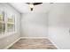 Well-lit bedroom featuring wood-look floors and window shutters at 2572 Daisy Dr, North Port, FL 34289