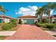 Single-story home with a light green garage door and brick driveway at 2572 Daisy Dr, North Port, FL 34289