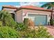 Single-story home with a light green garage door and brick driveway at 2572 Daisy Dr, North Port, FL 34289