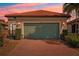 House exterior featuring a two-car garage and brick driveway at 2572 Daisy Dr, North Port, FL 34289