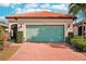 Single-story home with a light green garage door and brick driveway at 2572 Daisy Dr, North Port, FL 34289