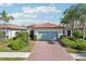 Single-Gathering home with a teal garage door and brick driveway at 2572 Daisy Dr, North Port, FL 34289