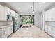 Bright kitchen with white cabinets, granite island, and sliding doors to patio at 2572 Daisy Dr, North Port, FL 34289