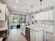 Modern kitchen features island, stainless steel appliances, and view to backyard at 2572 Daisy Dr, North Port, FL 34289
