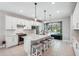 Open kitchen boasts white cabinets, stainless steel appliances & breakfast bar at 2572 Daisy Dr, North Port, FL 34289