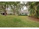Spacious backyard with lush green lawn and mature trees at 263 Southampton Dr # 301, Venice, FL 34293
