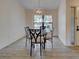 Chic dining room with a glass table, four chairs, a unique chandelier, and wood look flooring at 263 Southampton Dr # 301, Venice, FL 34293