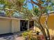 Inviting home entrance with decorative shrubbery, trees, and a two car garage on the left at 263 Southampton Dr # 301, Venice, FL 34293