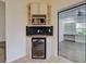 Corner kitchen area with microwave, custom cabinets, a wine cooler, and stone countertops at 263 Southampton Dr # 301, Venice, FL 34293
