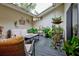 Enclosed sunroom patio with cozy seating, a skylight, and an array of potted plants at 263 Southampton Dr # 301, Venice, FL 34293