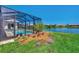 Landscaped backyard with a screened pool and lake view at 2878 Egret Ct, North Port, FL 34287